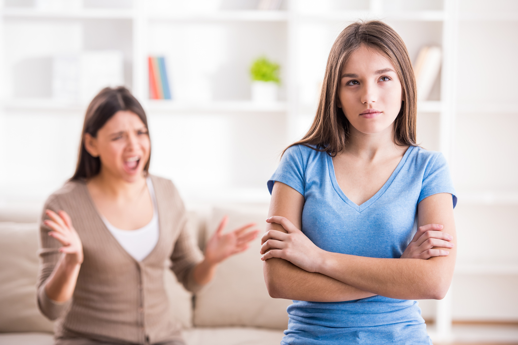 Young mother in a discussion with her teenage daughter. Problems between generations concept.